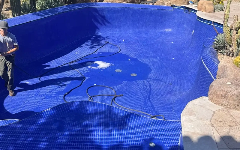 Drained swimming pool in a desert-style backyard during a professional drain and wash service that helps extend the life of pool plaster and equipment.