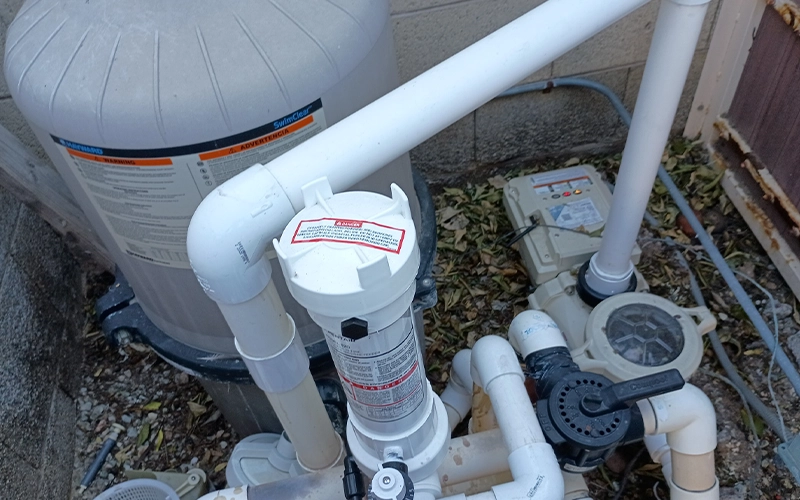Hayward SwimClear pool filter with inline chlorinator and pump installed on a residential pool equipment pad.