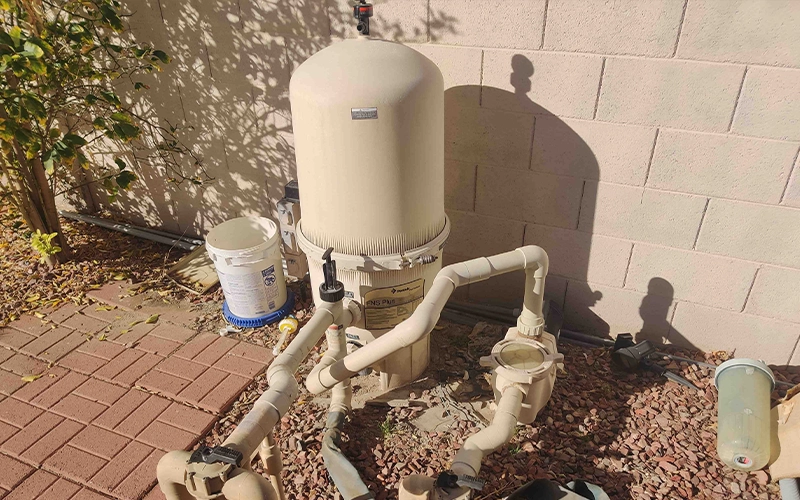 Pentair FNS Plus cartridge filter installed on a residential pool equipment pad with pool pump, plumbing, and isolation valves for pool filtration.