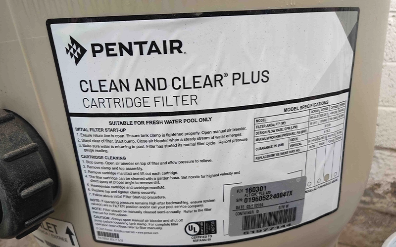 Close-up of a Pentair Clean & Clear Plus cartridge filter label on residential pool equipment, showcasing a trusted Pentair pool filtration system