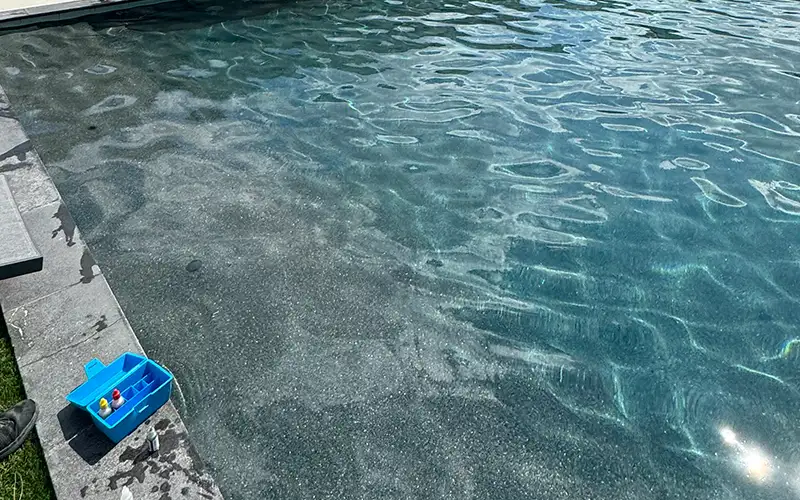 Pool cleaning technician checking water chemistry in a Scottsdale or Mesa swimming pool