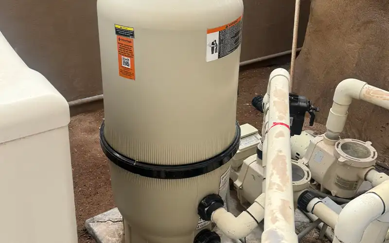 Residential pool equipment featuring a pool pump, cartridge filter, and plumbing system designed for reliable water circulation and efficient filtration.
