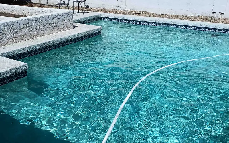 Close-up view of pool water showing surface clarity issues that require regular pool maintenance in Arizona